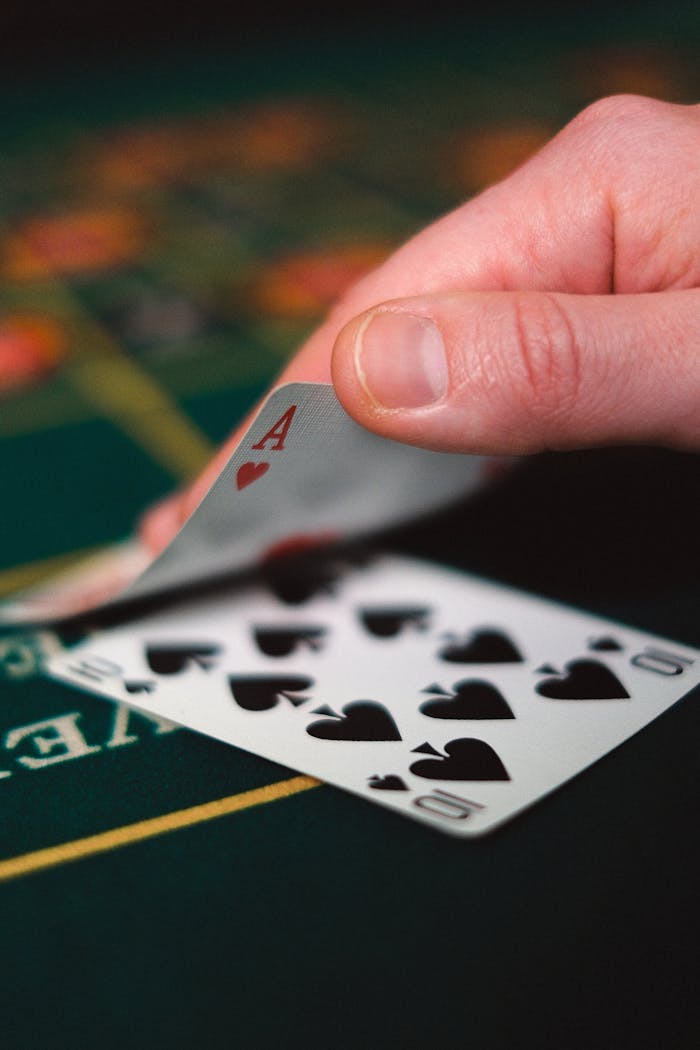 why-choose-us Tense moment in a casino with a hand revealing a winning card on a table.